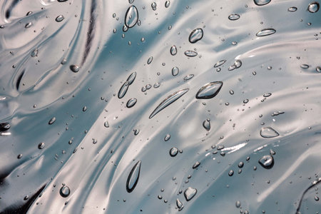 Water drops on a glass surface. Abstract background and texture for design.の写真素材