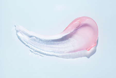 Lip gloss pink transparent color smudge sample isolated on blue background