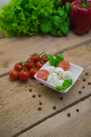 Mozzarella cheese in a bowl on a wooden tableの写真素材