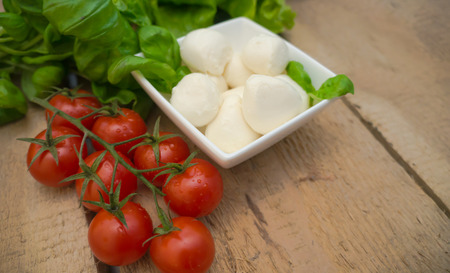 Mozzarella cheese in a bowl on a wooden tableの写真素材