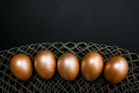 golden easter eggs on black backgroundの写真素材