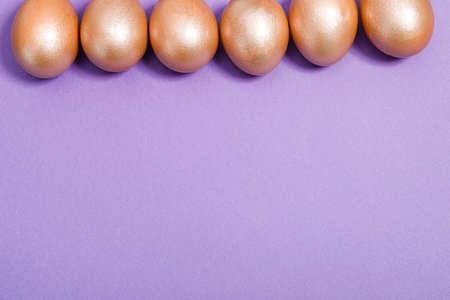 golden easter eggs on purple backgroundの写真素材