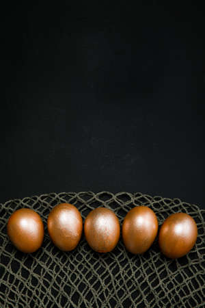 golden easter eggs on black backgroundの写真素材