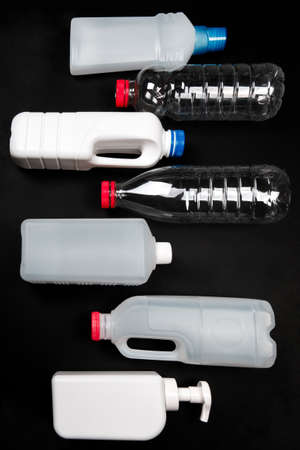 Plastic bottle on black background. High density polyethylene packaging for recycling. Place for...