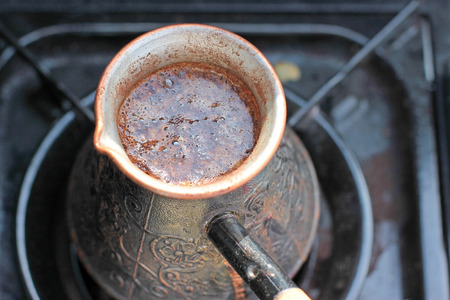 Hot coffee prepared in turk on gas. Closeup.の写真素材