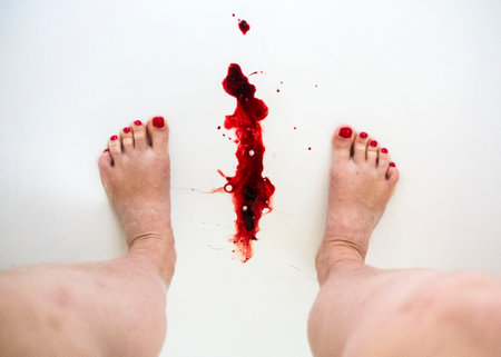 Menstruation blood and women feet in a shower on the white background. Menstruation cycle period, woman hygiene.の写真素材
