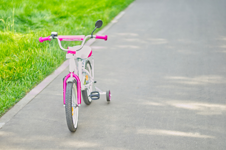 Small pink tricycle for children standing on the road.の写真素材