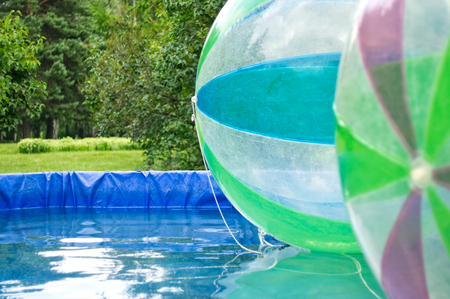 Big air balloons floating in the pool. Entertainment for children in the park, outdoor activities. Attractions for children.の写真素材