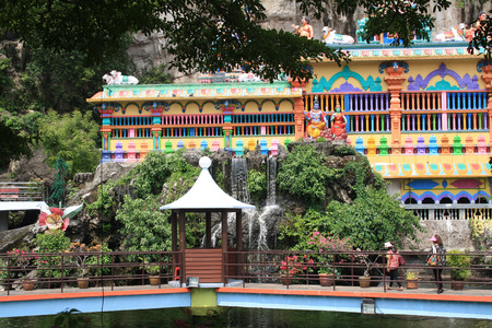 Pond with artificial waterfalls, bridges and gazebos for relaxing on the background of a Hindu temple in the Batu caves complexのeditorial素材