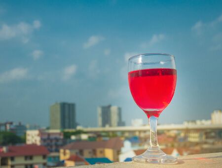 Red wine glass with city view as backgroundの写真素材