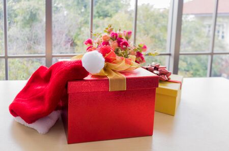 Red Christmas gift box tied with a beautiful ribbon placed on a wooden floor. Idea for giving gifts to lovers on Christmas Day.の写真素材