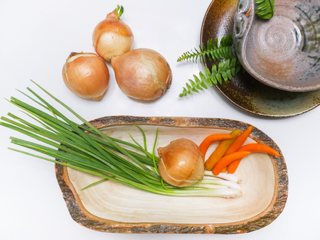 vegetables / onions, spring onions, orange chilis set on white tableの写真素材