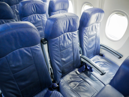 Interior of commercial airplane cabin with blue passenger seats.の写真素材