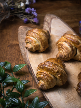 Fresh croissant a flaky, viennoiserie pastry on wooden board.の写真素材