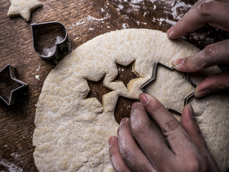 pastry chef hand use cutting mold to cut Cookie dough.