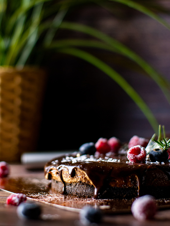 Chocolate cream tart cheesecake with fresh berries. delicious dessert for Birthday. Set on wooden table background.の写真素材