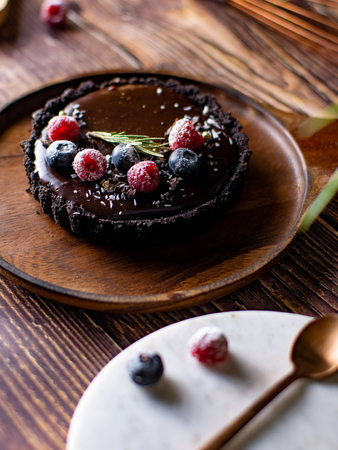 Tart Chocolate cheesecake with fresh berries. delicious dessert for Birthday. Set on wooden table background.の写真素材