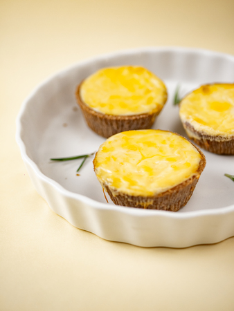 Baked Portuguese egg custard tarts in white plate on yellow background.の写真素材