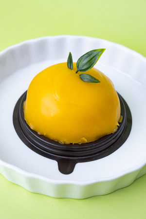 delicious orange dome cake. Set on green background.の写真素材