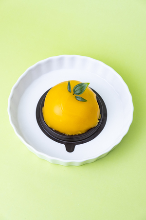 delicious orange dome cake. Set on green background.の写真素材