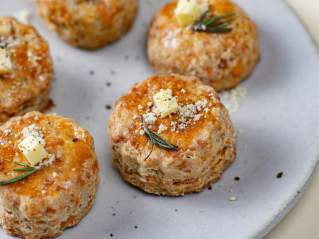 Homemade Cheese Scones with butter in white plate on yellow background.の写真素材