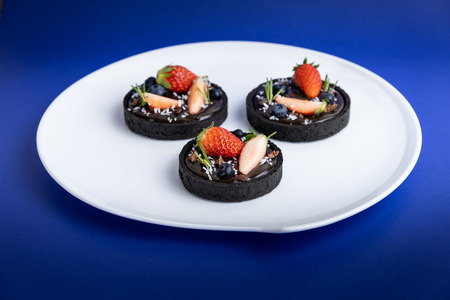 Cookie crust chocolate tart with Blueberry and strawberry.の写真素材