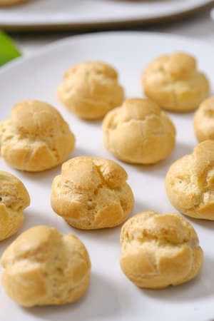 choux cream or cream puff or French profiteroles with fresh cream set on cafe table.の写真素材