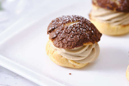 choux cream or cream puff or French profiteroles with fresh cream set on cafe table.の写真素材