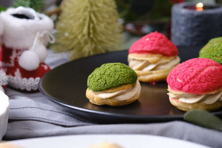 christmas choux cream or cream puff or French profiteroles with fresh cream set on cafe table.の写真素材