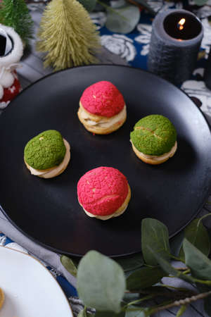 christmas choux cream or cream puff or French profiteroles with fresh cream set on cafe table.の写真素材