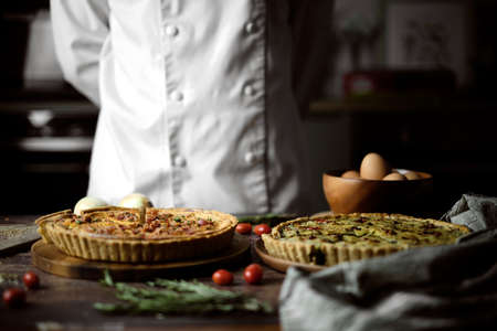 Homemade cheesy quiche for brunch. set on wooden cafe table background.