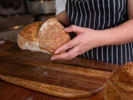 Artisan Sourdough Bread in Hand â Fresh from the Oven.の写真素材