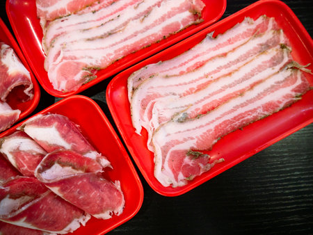 Sliced Meat and belly pork in tray for shabu or Sichuan mala hotpot on restaurant table.の写真素材