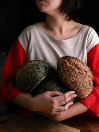 Woman hand hold fresh baked sourdough bread. Presenting Homemade ciabatta breadの写真素材