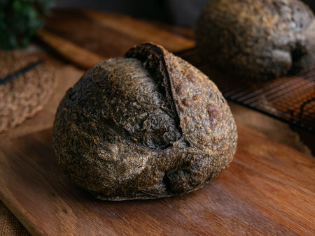 loaf of fresh baked black charcoal sourdough bread. Black ciabatta bread with activated carbonの写真素材