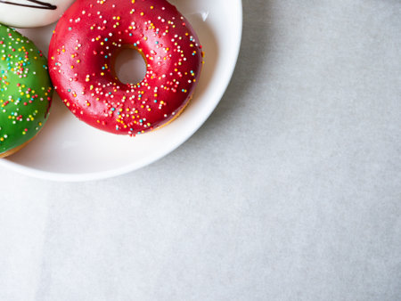 Donuts with colorful icing glazed designs on a white background. Copy free spaceの写真素材