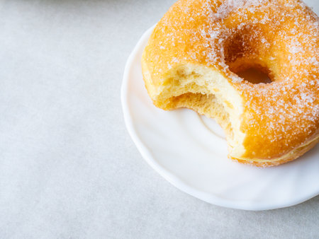 Donuts with sugar sprinkles with bite mark on a white background.の写真素材