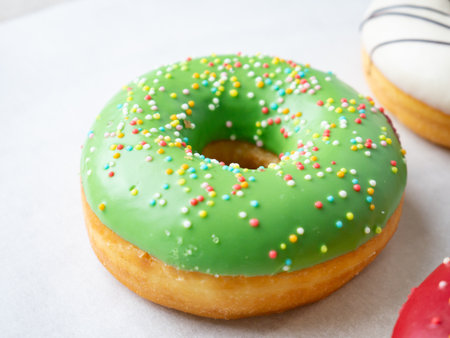 Donuts with different colorful icing designs on a white background.の写真素材