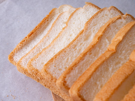 Toasted white bread loaf sliced on white background.