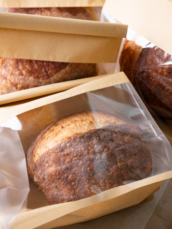 Sourdough Bread Loaf in Transparent Plastic Bag on White Background