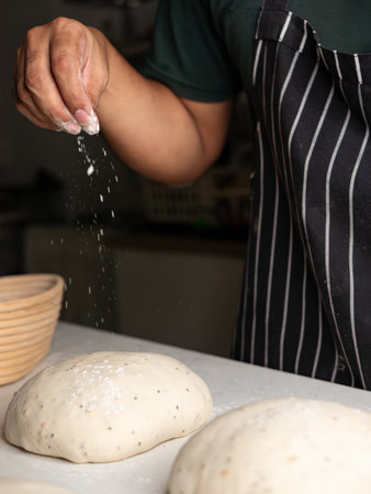 Baker Sprinkling Flour on Sourdough Dough - Artisan Breadmaking Process