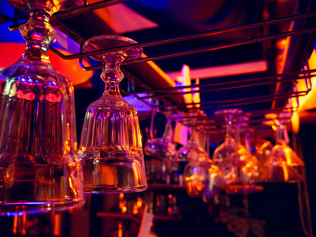 Cocktail and wine glass hanging over bar counter.