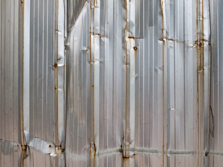 Old Corrugated Metal Sheet Fence with Rust and Dents.の写真素材