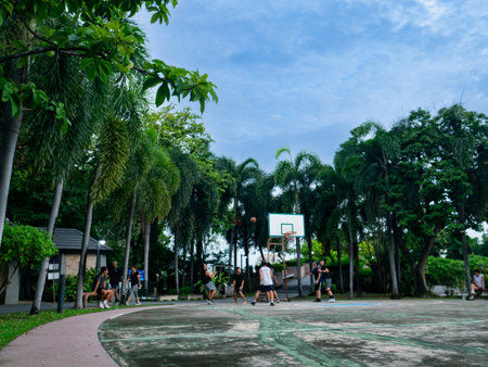 Blurred Basketball Court with Group of People Playing Game Outdoors.の写真素材