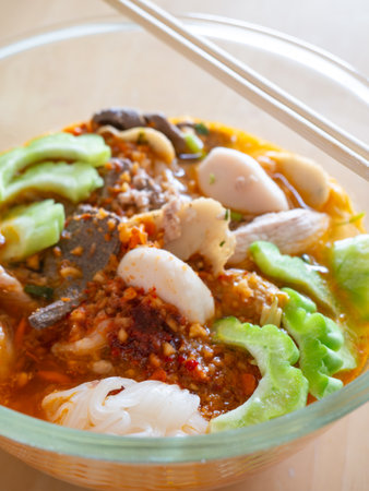 Traditional Thai Tom Yum Noodle Soup with Pork, Meatballs, Dried Shrimp and Pork Liver in Authentic...