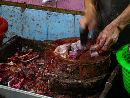 Fish Vendor Cutting Fresh Fish on a Wooden Chopping Board at Market.の写真素材