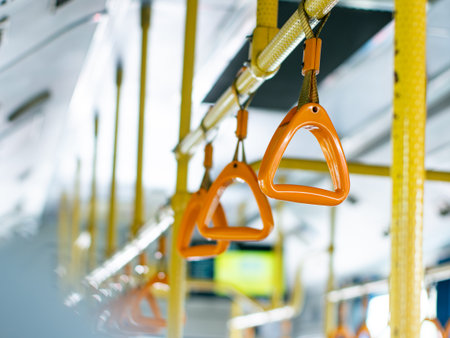 Passenger handholds and grab bars inside public transportation bus or train - safety support handles for commuters in urban transit vehicle.の写真素材