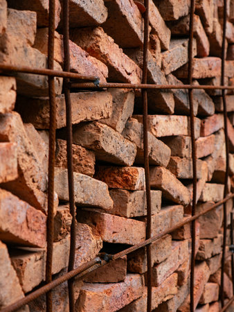 Stacked Red Clay Bricks in Construction Site - Traditional Building Materials Organized in Storage...