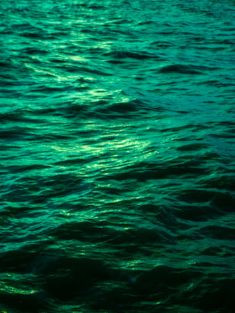 Turquoise Green Ocean Water Waves Surface with Golden Light Reflection - Tropical Sea Texture Background Patternの写真素材