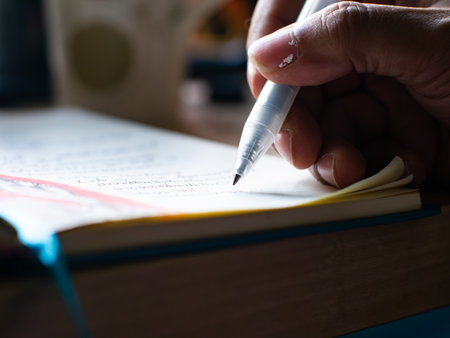 Close-up Hand Writing Notes with Pen in Notebook - Student Study Session and Academic Learning Process.の写真素材